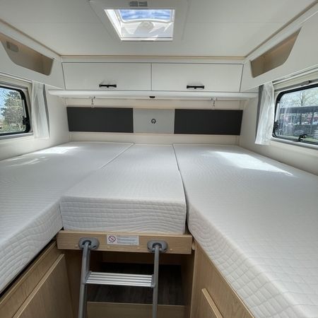 Innenraum eines Wohnmobils mit zwei gemütlichen Betten