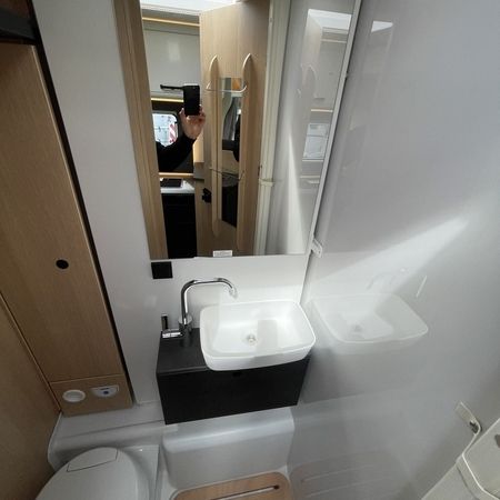 Ein Badezimmer mit Waschbecken, Toilette und einem Spiegel an der Wand