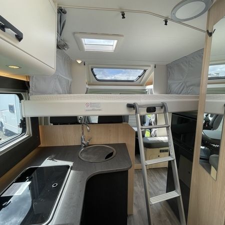 Innenraum eines Wohnmobils mit Waschbecken und einer Leiter